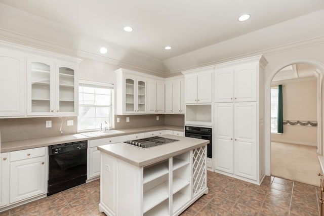 kitchen with arched walkways, black appliances, open shelves, and white cabinets