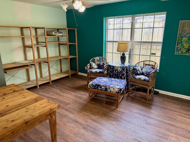 sitting room with baseboards, a ceiling fan, and wood finished floors