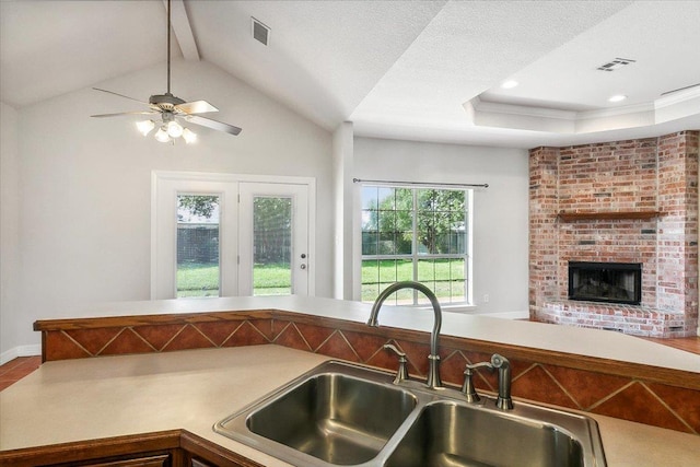 kitchen featuring a sink, visible vents, lofted ceiling, and open floor plan