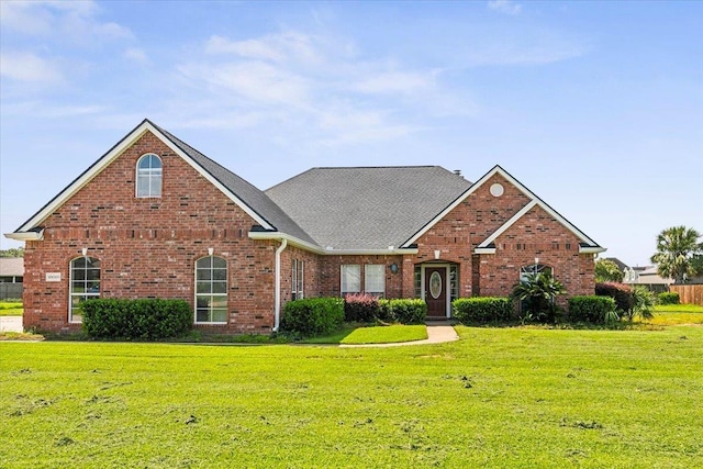 traditional-style home with brick siding and a front lawn