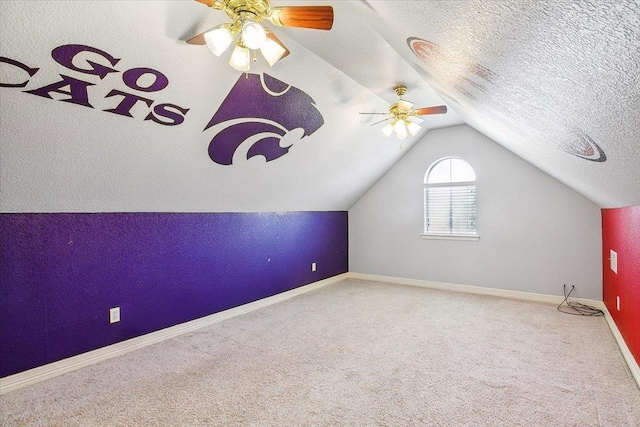 additional living space with baseboards, vaulted ceiling, carpet flooring, a textured ceiling, and a ceiling fan