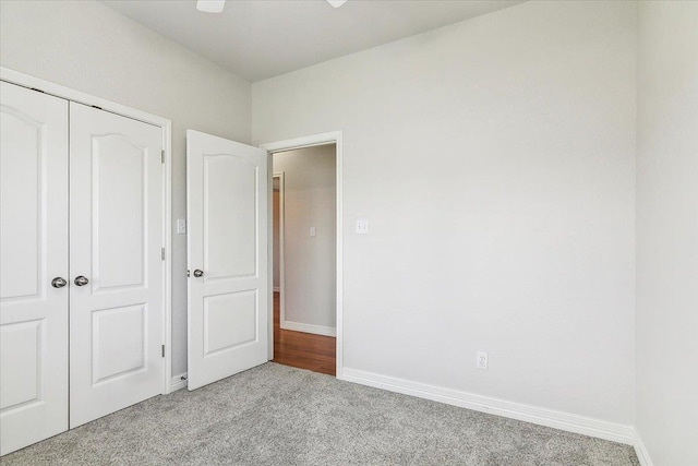 unfurnished bedroom with a closet, baseboards, and carpet flooring