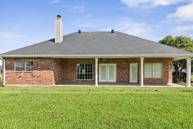 back of property featuring a patio, brick siding, and a lawn