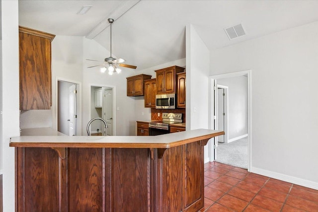 kitchen with lofted ceiling with beams, visible vents, a kitchen bar, and appliances with stainless steel finishes