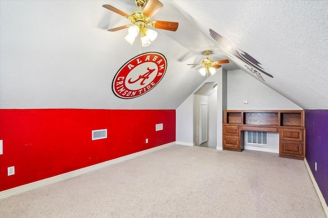 bonus room featuring baseboards, visible vents, carpet floors, lofted ceiling, and a textured ceiling