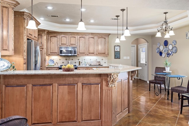 kitchen featuring appliances with stainless steel finishes, arched walkways, decorative backsplash, a tray ceiling, and visible vents