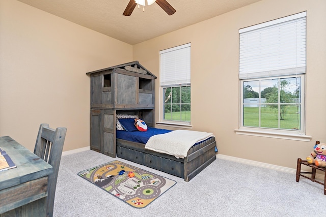 bedroom with baseboards, a ceiling fan, carpet, and multiple windows