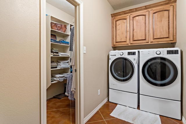 laundry area with cabinet space, tile patterned floors, washing machine and dryer, and baseboards