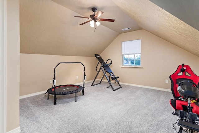 interior space with a textured ceiling, visible vents, baseboards, and vaulted ceiling