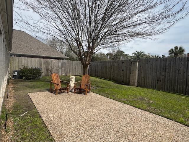 view of yard with cooling unit, a fenced backyard, and a patio