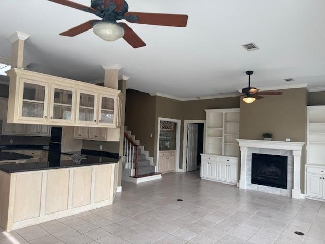 kitchen with a fireplace, crown molding, visible vents, a ceiling fan, and open floor plan