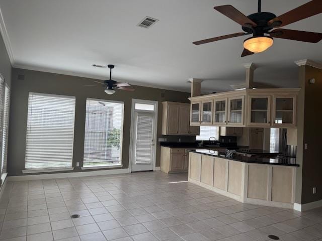 kitchen with dark countertops, crown molding, visible vents, and glass insert cabinets