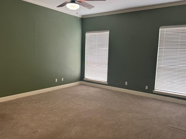 empty room featuring baseboards, carpet, a ceiling fan, and crown molding