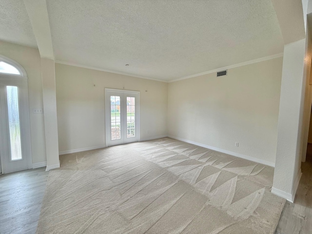 unfurnished room featuring crown molding, baseboards, visible vents, and a textured ceiling