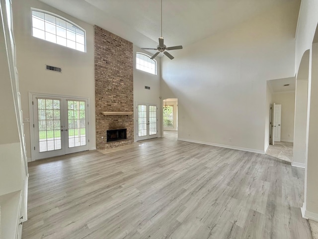 unfurnished living room with visible vents, baseboards, a ceiling fan, light wood-style floors, and french doors