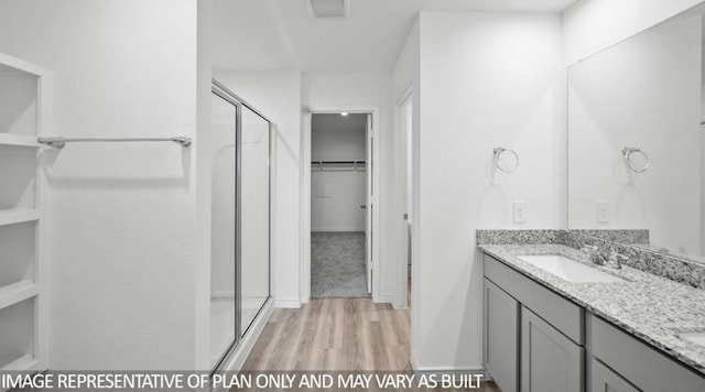 1670 Haidlyns Way, Sour Lake, TX 77659 - bathroom featuring wood finished floors, a shower stall, vanity, and a spacious closet