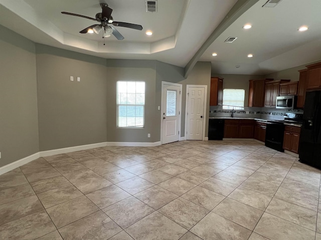 kitchen with black appliances, light tile patterned flooring, ceiling fan, and a raised ceiling