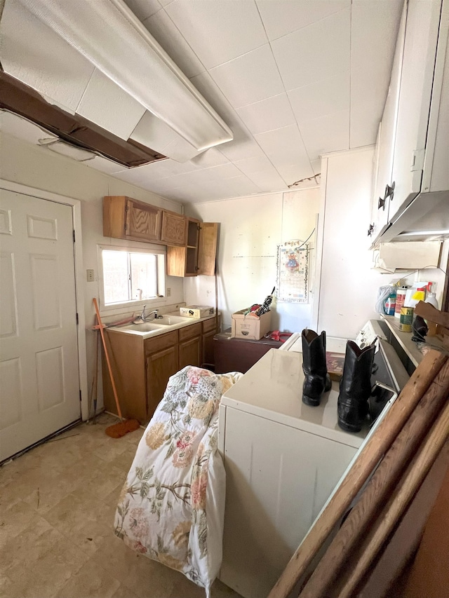 kitchen featuring light countertops, brown cabinetry, and a sink