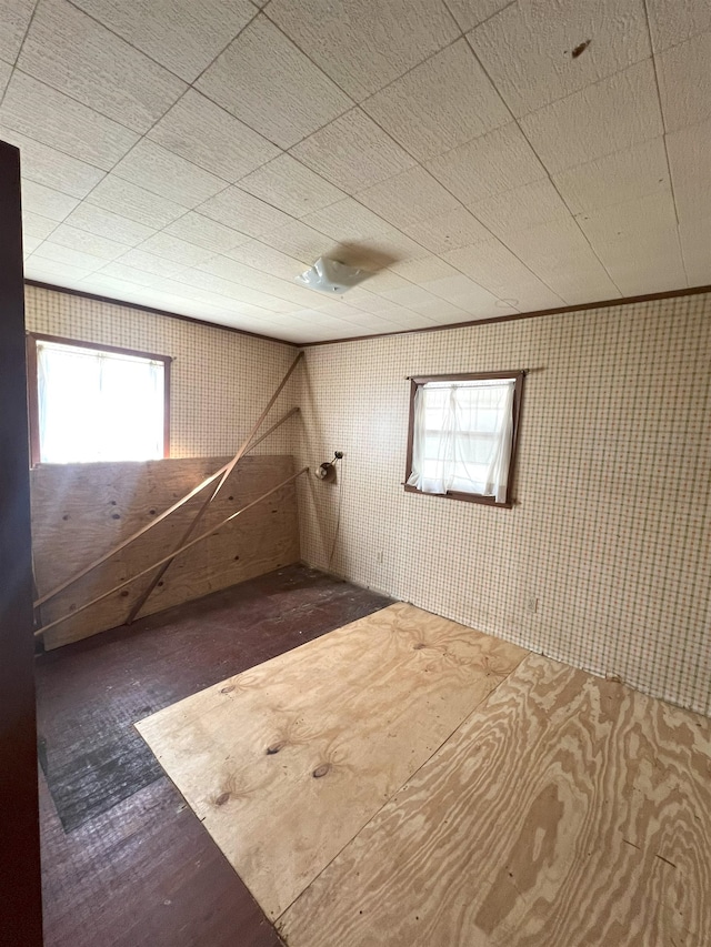 spare room featuring wood finished floors and wallpapered walls