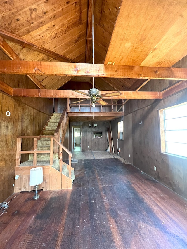 unfurnished living room featuring vaulted ceiling, ceiling fan, stairway, and wood finished floors