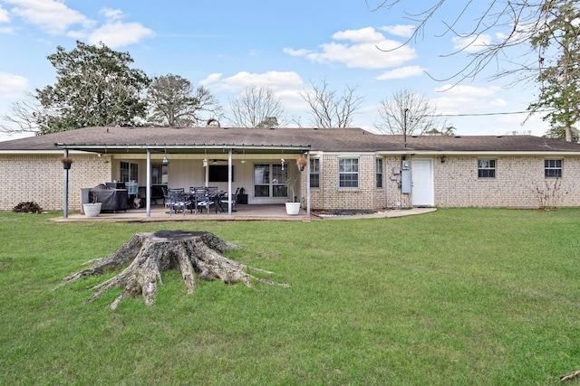 back of house with a yard, brick siding, a patio, and ceiling fan