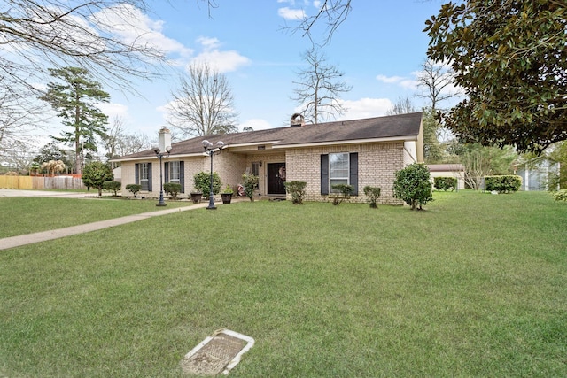 view of front of home with a chimney, a front lawn, and brick siding