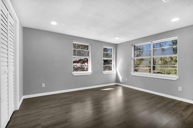 unfurnished room with dark wood-style floors and baseboards