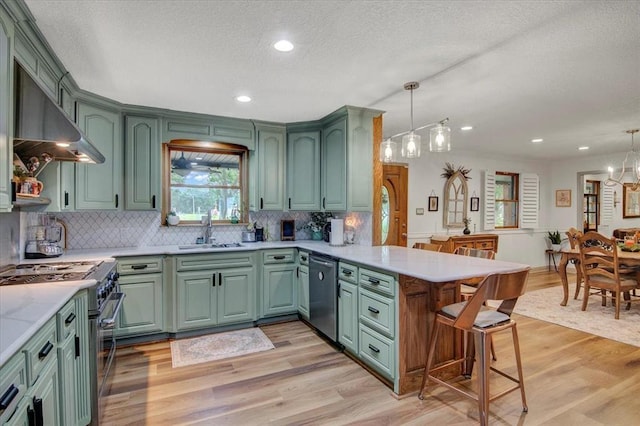 2999 59th St, Port Arthur, TX 77640 - kitchen with green cabinets, stainless steel appliances, a sink, a textured ceiling, and wainscoting