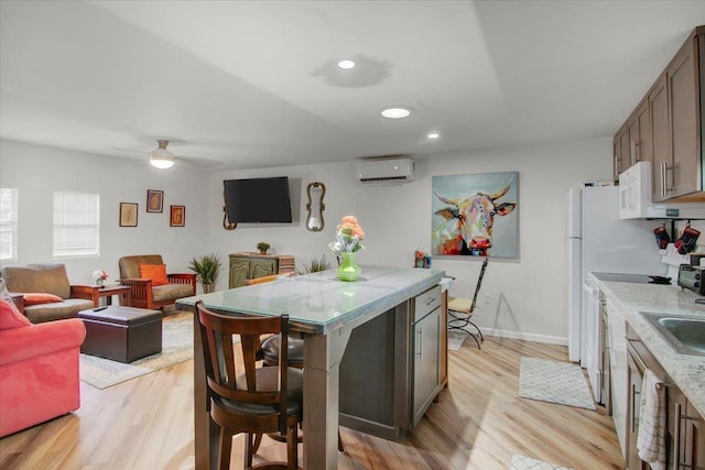 2999 59th St, Port Arthur, TX 77640 - kitchen with a wall mounted air conditioner, light wood-style flooring, recessed lighting, white microwave, and ceiling fan