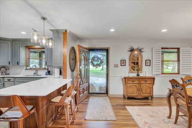 2999 59th St, Port Arthur, TX 77640 - kitchen with a sink, gray cabinets, light countertops, light wood-style flooring, and ornamental molding