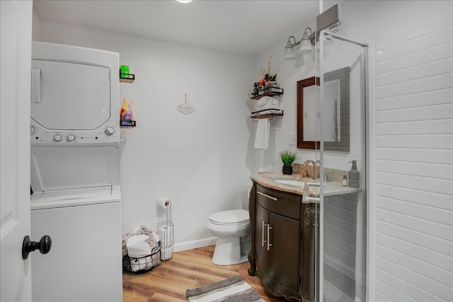 2999 59th St, Port Arthur, TX 77640 - full bath with stacked washing machine and dryer, vanity, wood finished floors, toilet, and a shower stall