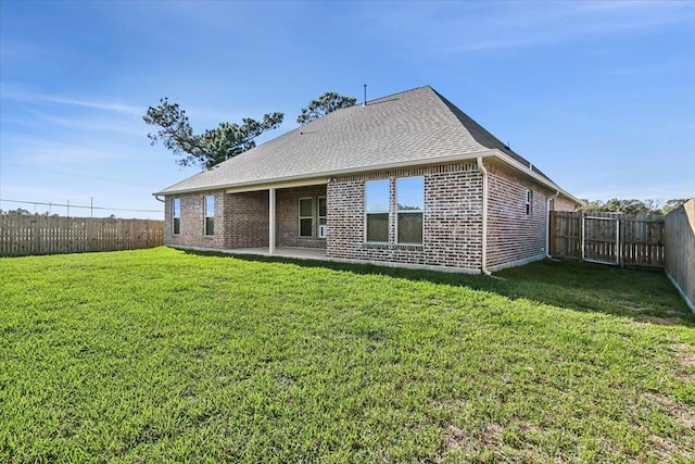 rear view of house featuring a yard and a patio