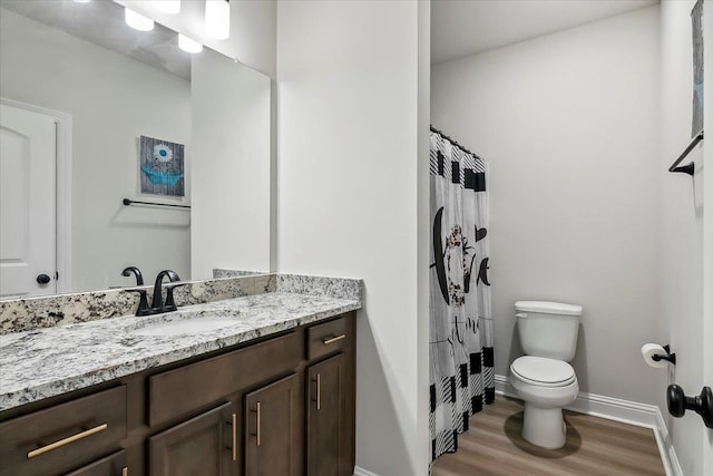 bathroom featuring hardwood / wood-style floors, vanity, toilet, and walk in shower