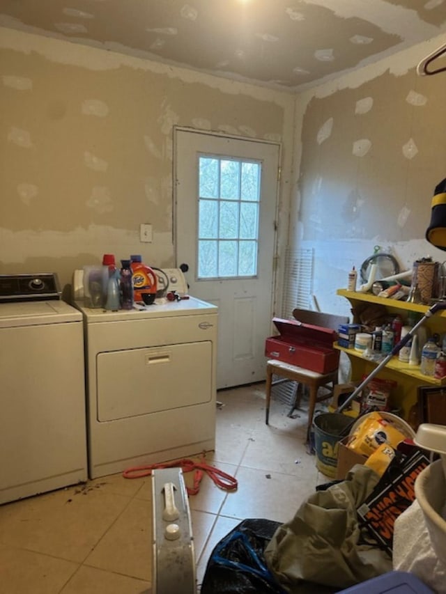 laundry area with separate washer and dryer and light tile patterned floors