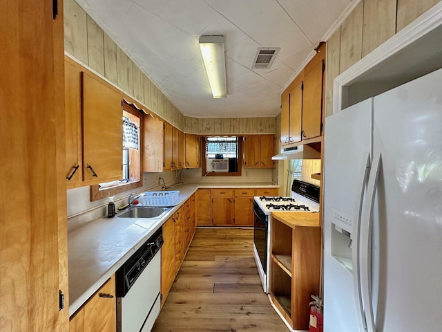 kitchen with light hardwood / wood-style floors, white appliances, sink, and cooling unit