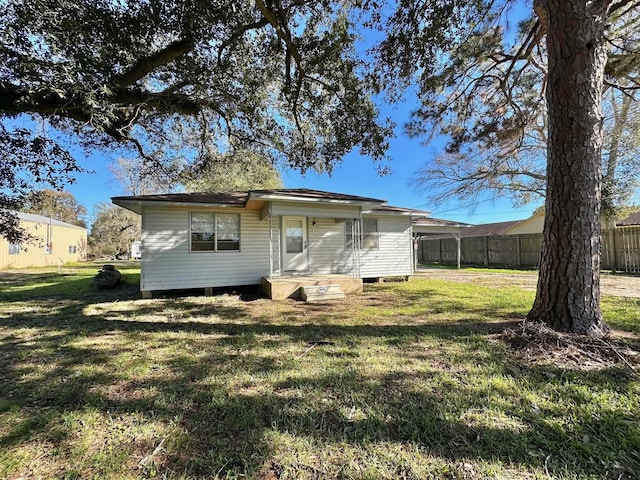 back of property featuring a yard and a carport