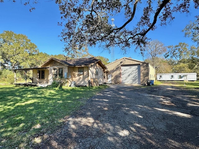 ranch-style home with a garage, a front lawn, and an outdoor structure