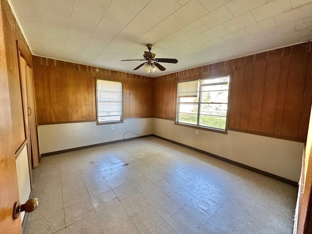 empty room with wooden walls and ceiling fan