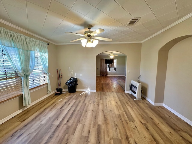 unfurnished living room featuring ceiling fan, ornamental molding, light hardwood / wood-style flooring, and heating unit