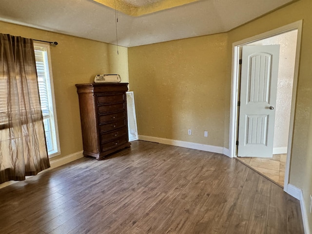 unfurnished bedroom featuring hardwood / wood-style flooring and multiple windows