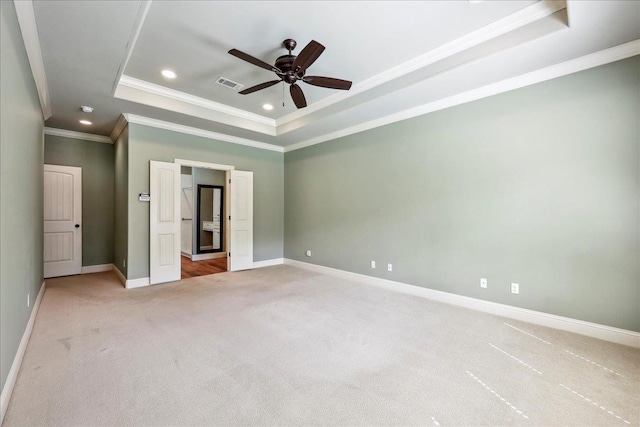 unfurnished bedroom with visible vents, recessed lighting, light carpet, a raised ceiling, and baseboards