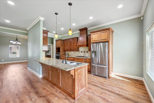 kitchen featuring custom exhaust hood, light stone counters, a sink, stainless steel appliances, and a notable chandelier
