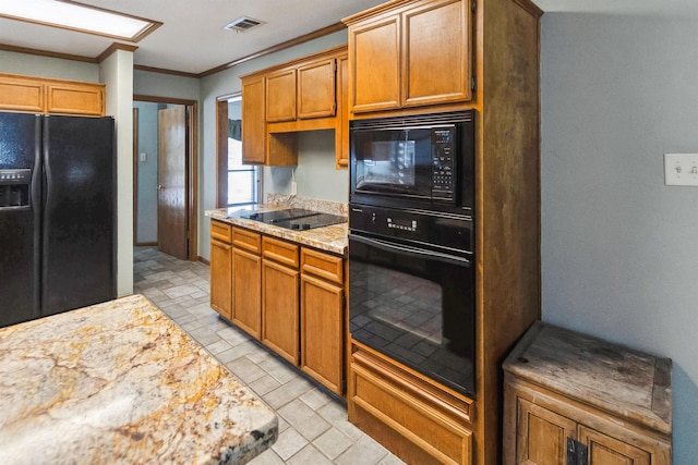 kitchen featuring visible vents, crown molding, stone finish flooring, light stone countertops, and black appliances