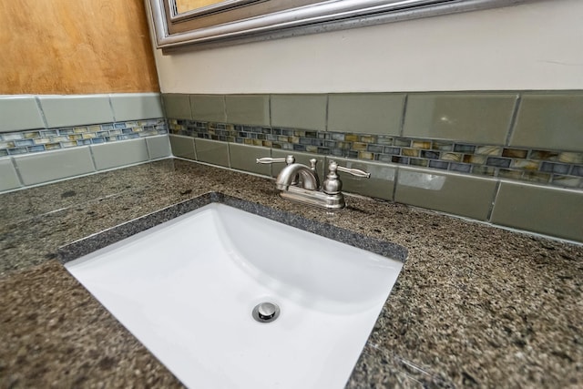 interior details with a sink and decorative backsplash