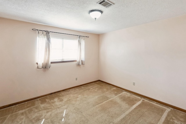 unfurnished room featuring baseboards, a textured ceiling, visible vents, and carpet
