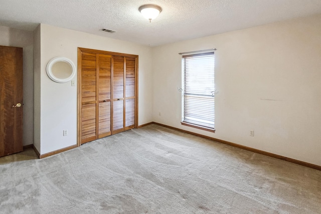unfurnished bedroom with a closet, carpet flooring, visible vents, and baseboards