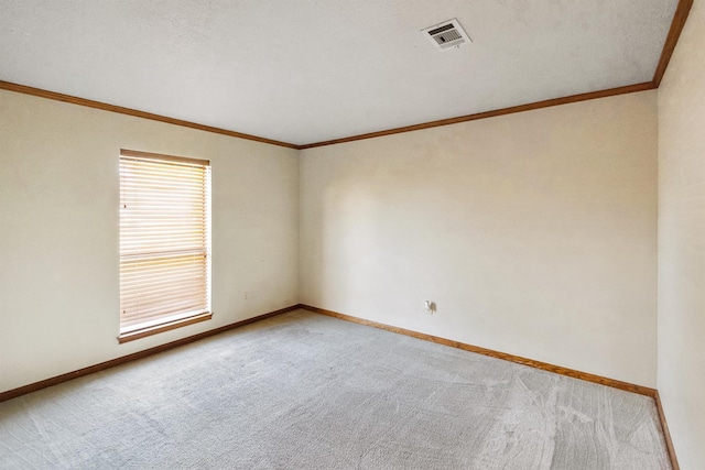 carpeted empty room featuring baseboards, visible vents, and crown molding