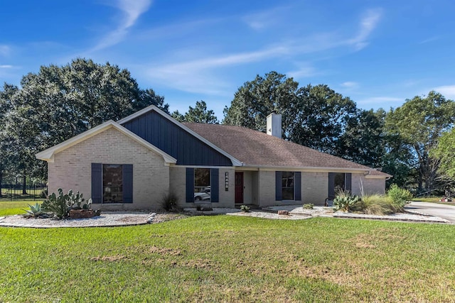single story home with brick siding, a chimney, and a front lawn