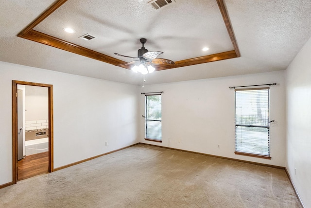 spare room with baseboards, visible vents, carpet flooring, and a raised ceiling