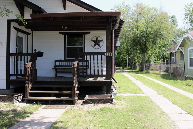 property entrance with covered porch and a lawn